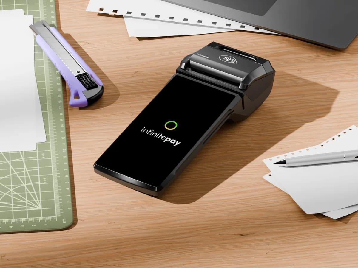InfinitePay card machine on a creative studio desk